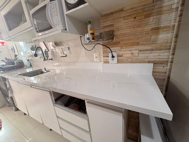Bancada branca com cooktop e cuba